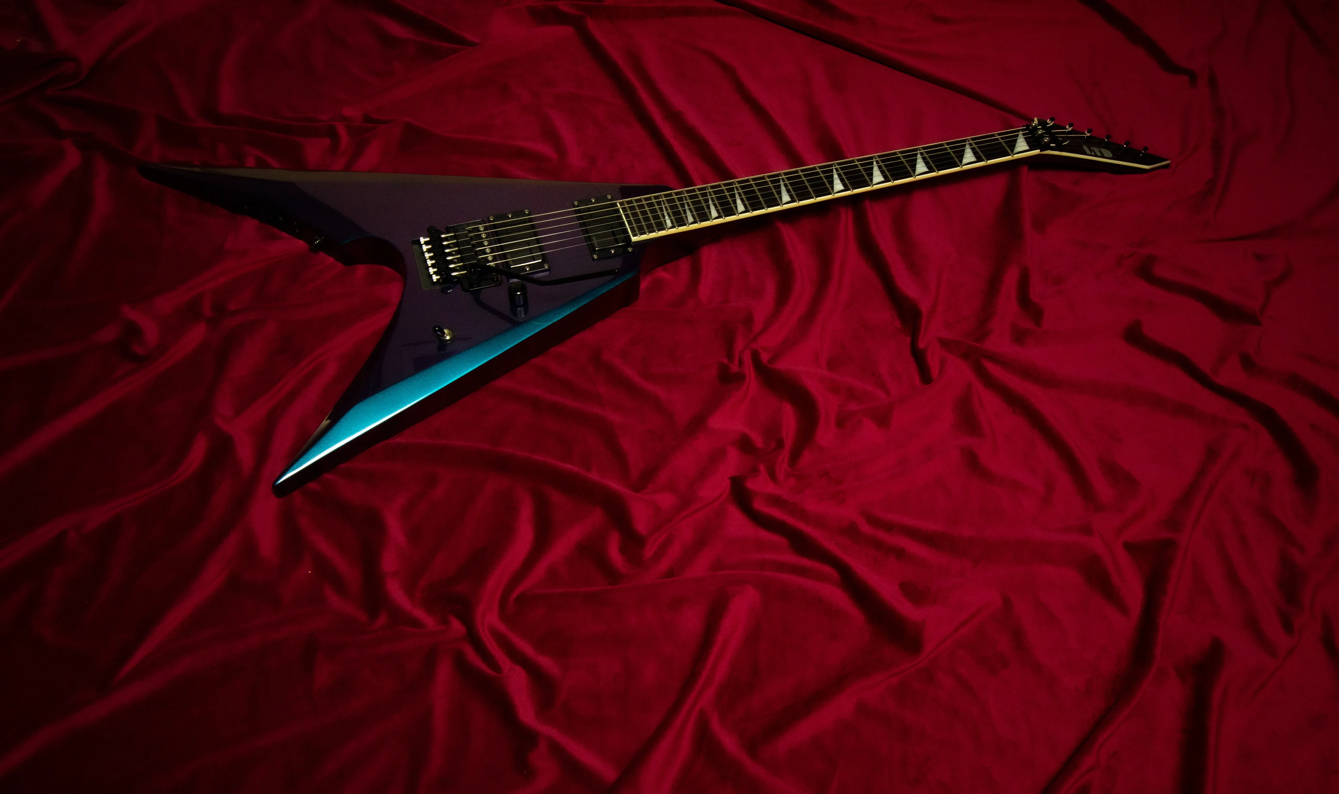 Gitara Septyma Guitars na tle czerwonej tkaniny — serwis gitar w Krakowie